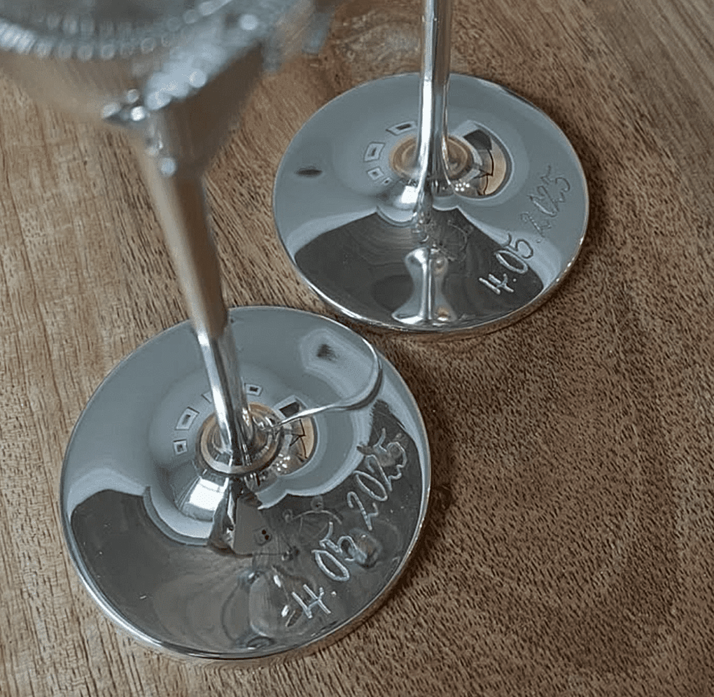 Close-up of engraved champagne flutes from a private party, featuring live calligraphy-style engraving on metal bases
